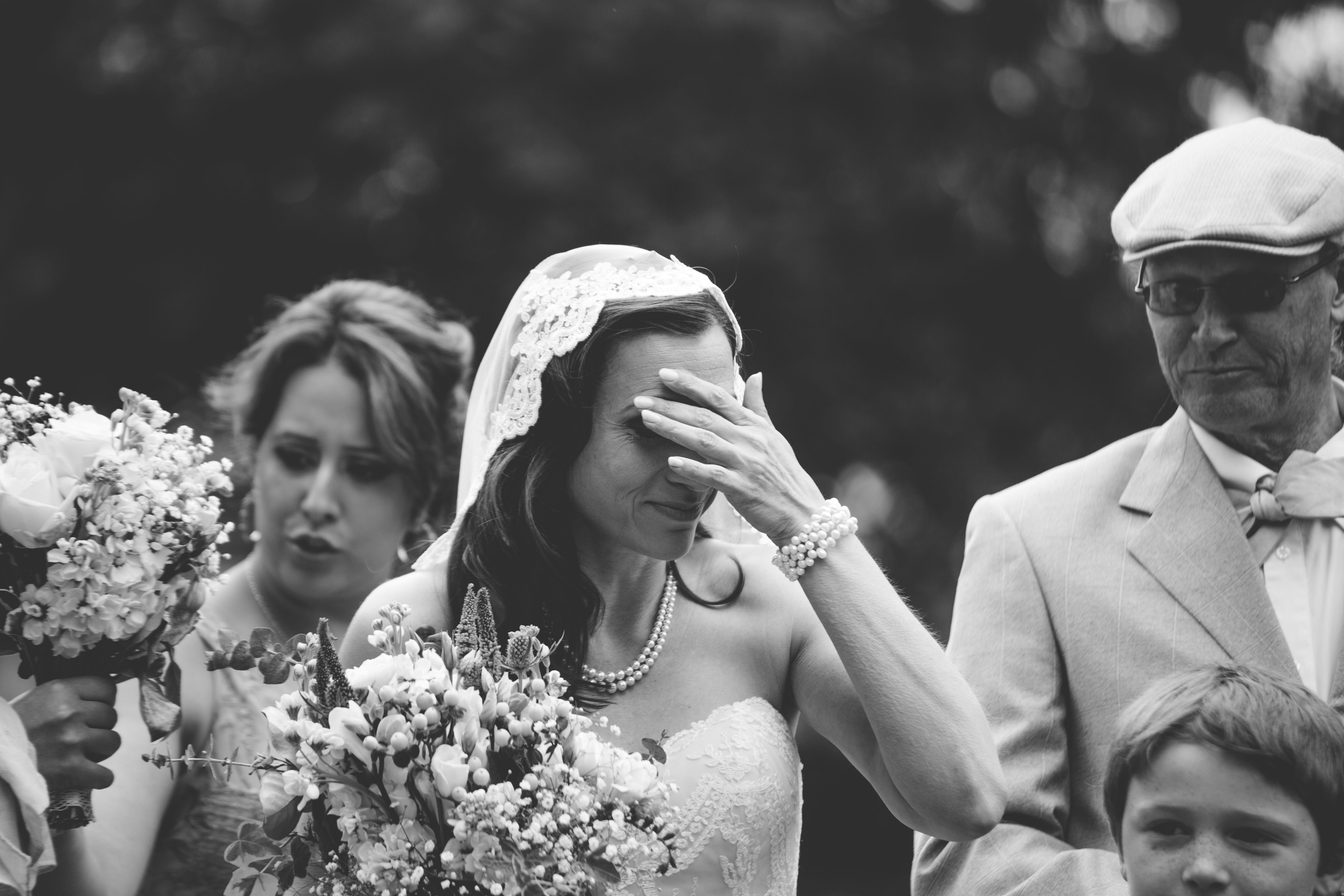 black and white photo of bride with hand to face