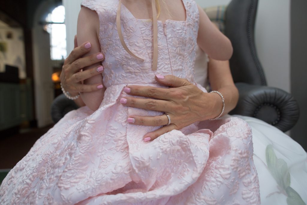 flower girl sat on knee of bride