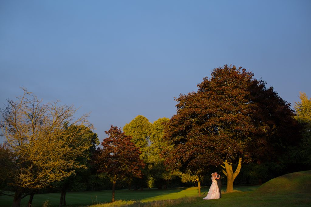 bride and groom stood in sun at Brocton Hall