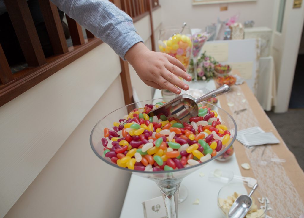 young wedding guest reaching for sweets