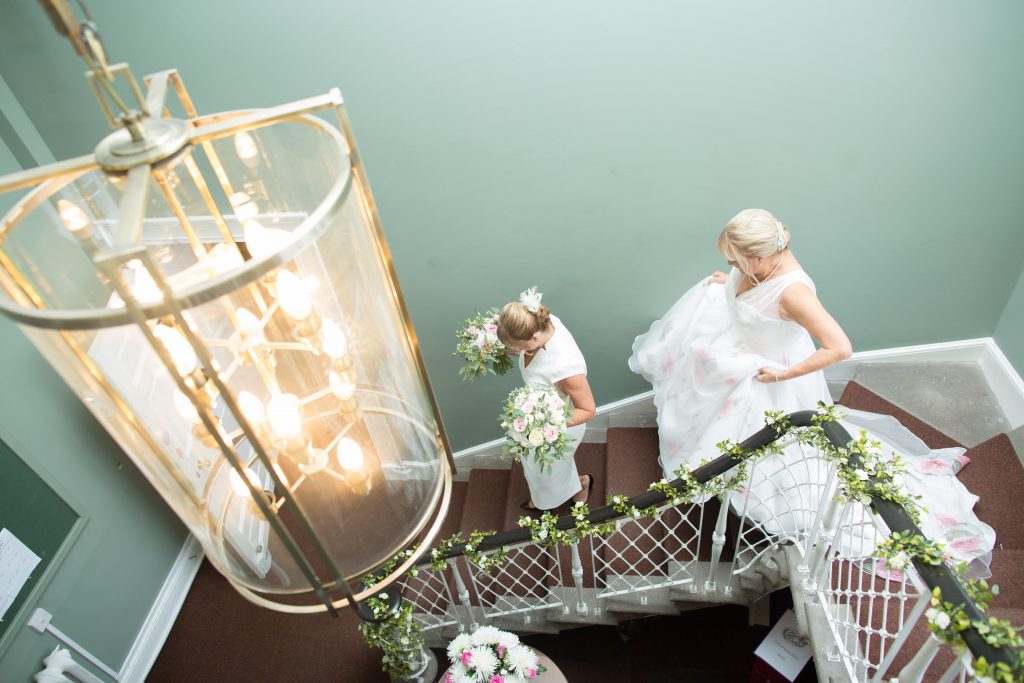 bride in wedding dress walking down staircase