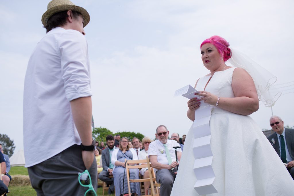 bride with pink hair reading wedding vows