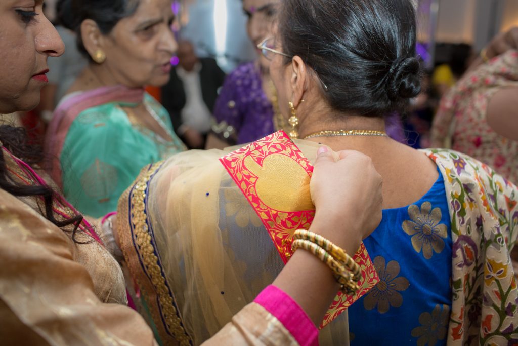 wedding guest having her sari adjusted