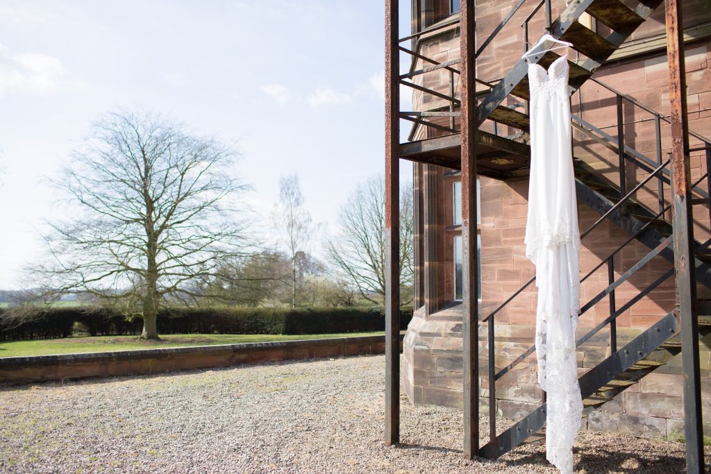 Enzoani Wedding dress hanging from metal staircase