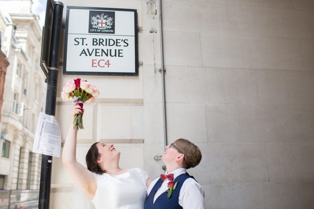 bride pointing at sign with bouquet