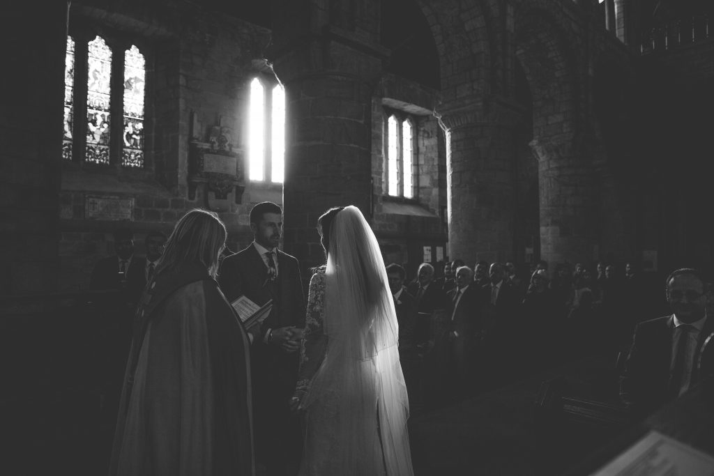 black and white photo of wedding ceremony inside a church
