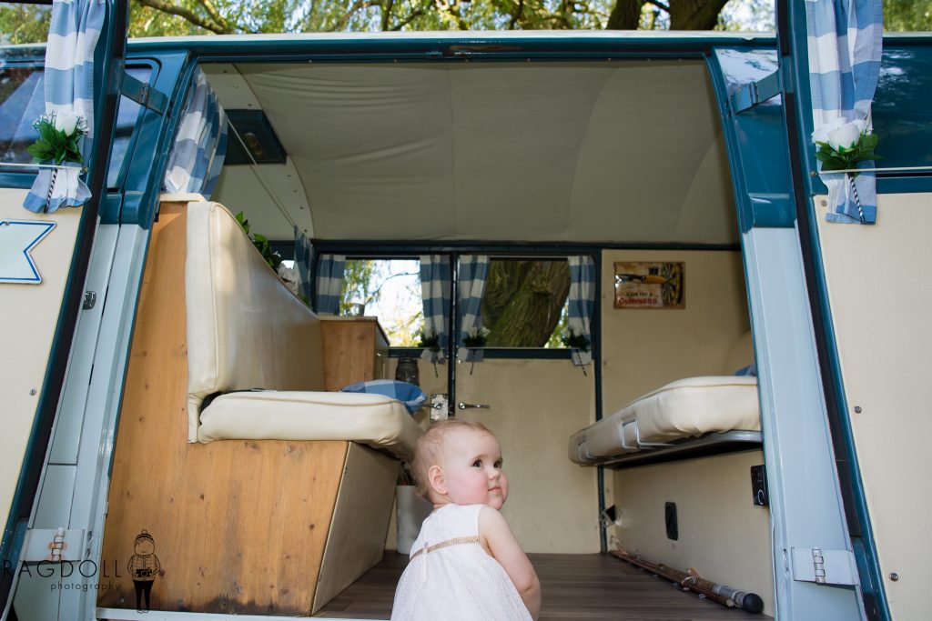 young flower girl climbing into camper van