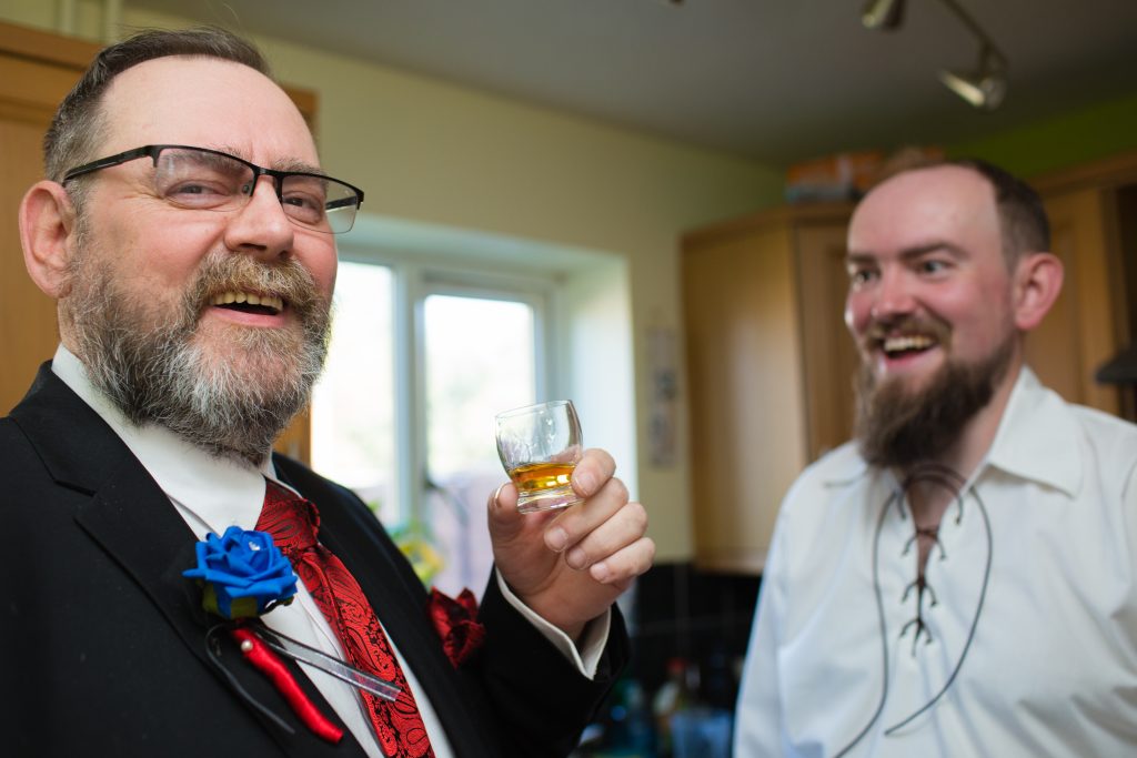 father of groom laughing with son