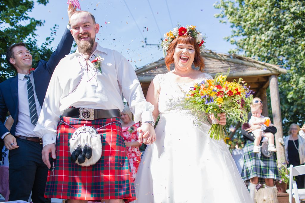 bride and groom having confetti thrown at them