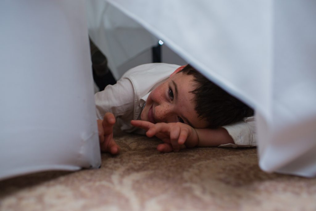 photo of young wedding guest under a table