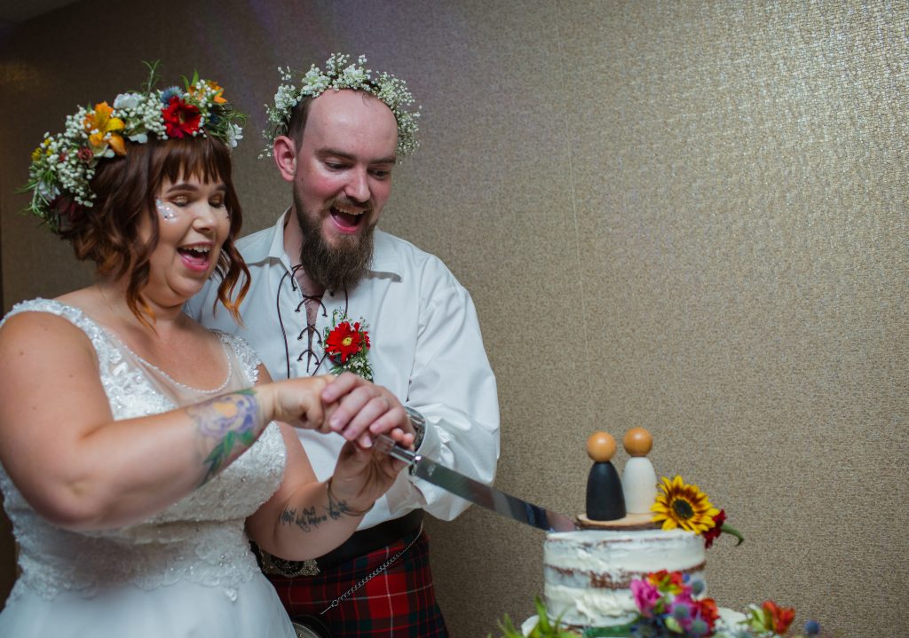 newly weds cutting wedding cake