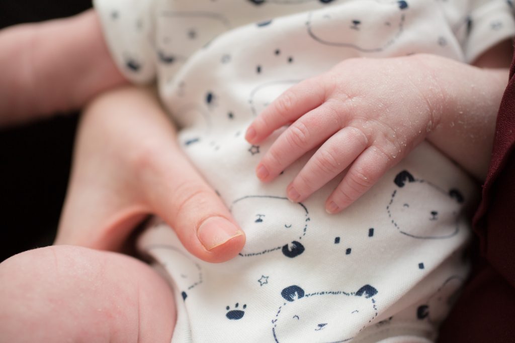 photo of adult hand and baby hand