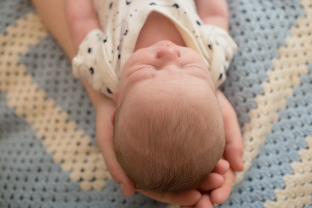 hands cradling head of newborn