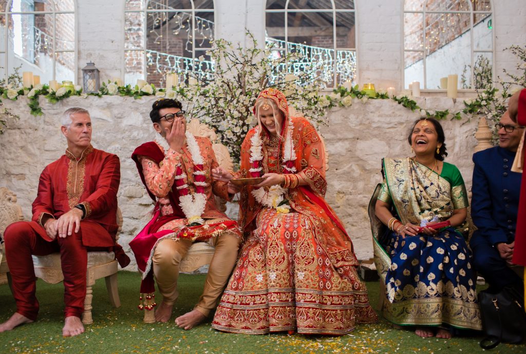 bride and groom laugh during hindu wedding ceremony