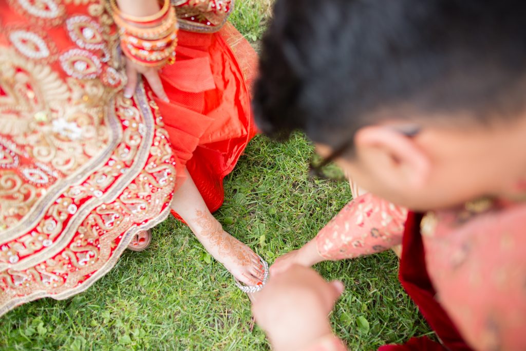 groom looking at henna on brides foot