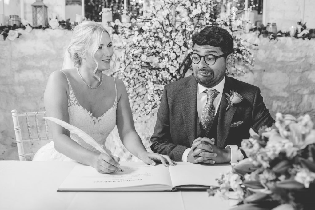 black and white photo of couple signing wedding register