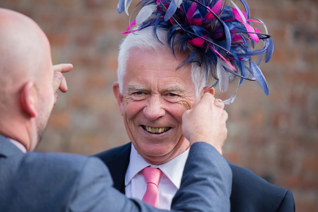 wedding guest trying on hat