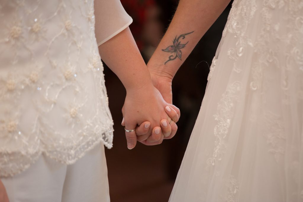 close up photo of brides holding hands