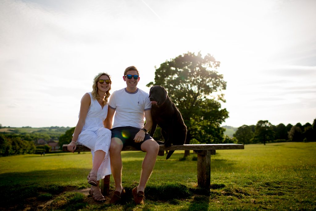 couple sat on bench with dog