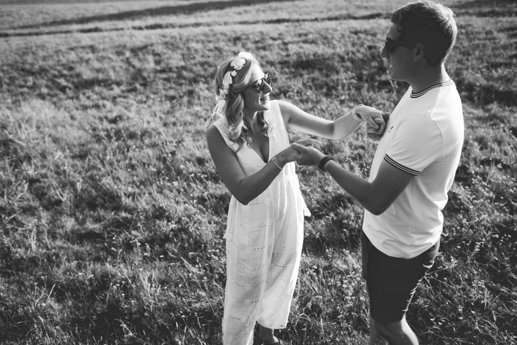 black and white photo of couple dancing in feild