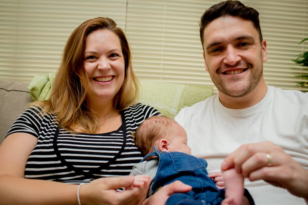 smiling parents with newborn son