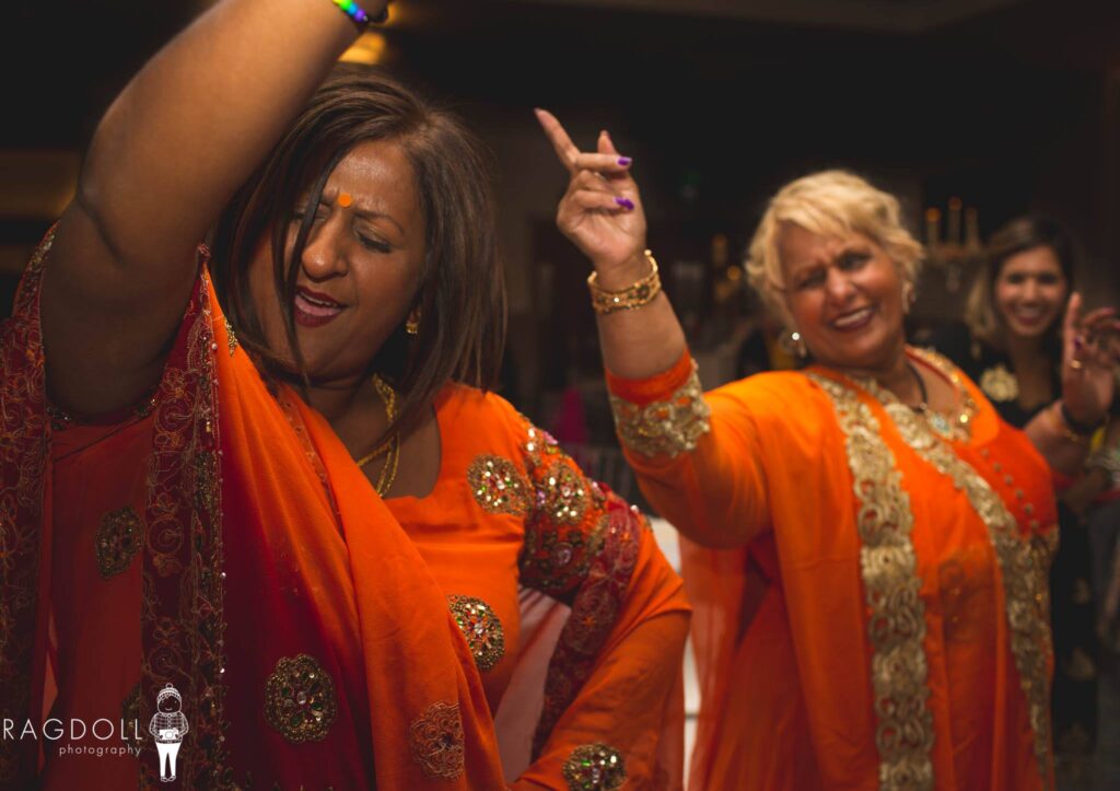 two guests in saris dancing at an indian wedding party