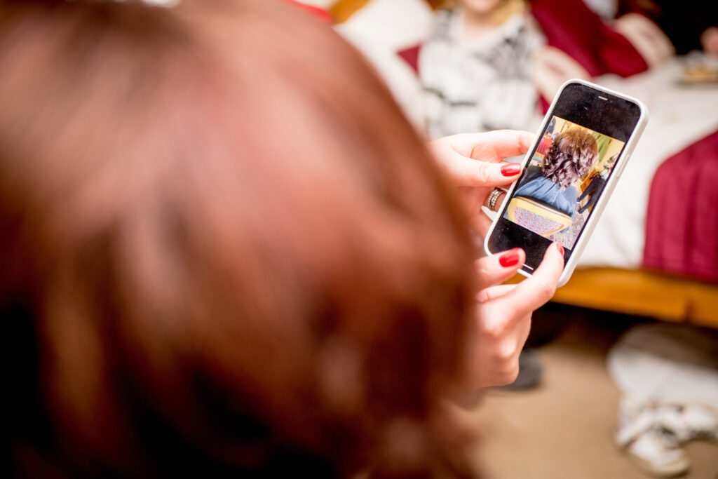 a bride being shown a photo of the back of her hair