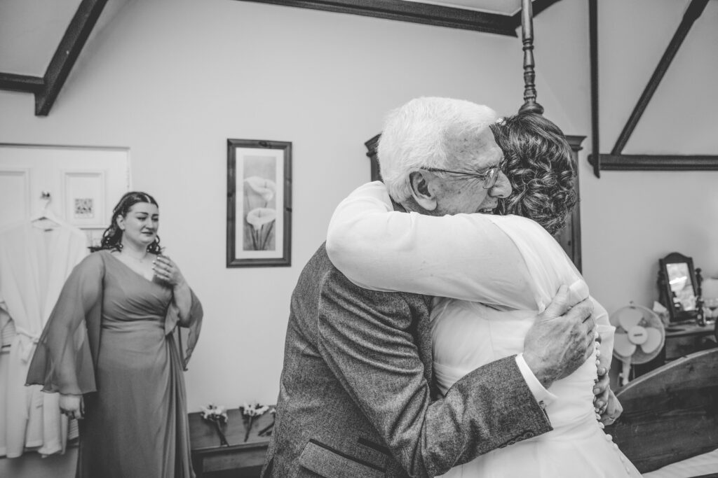black and white photo of a bride and her dad hugging