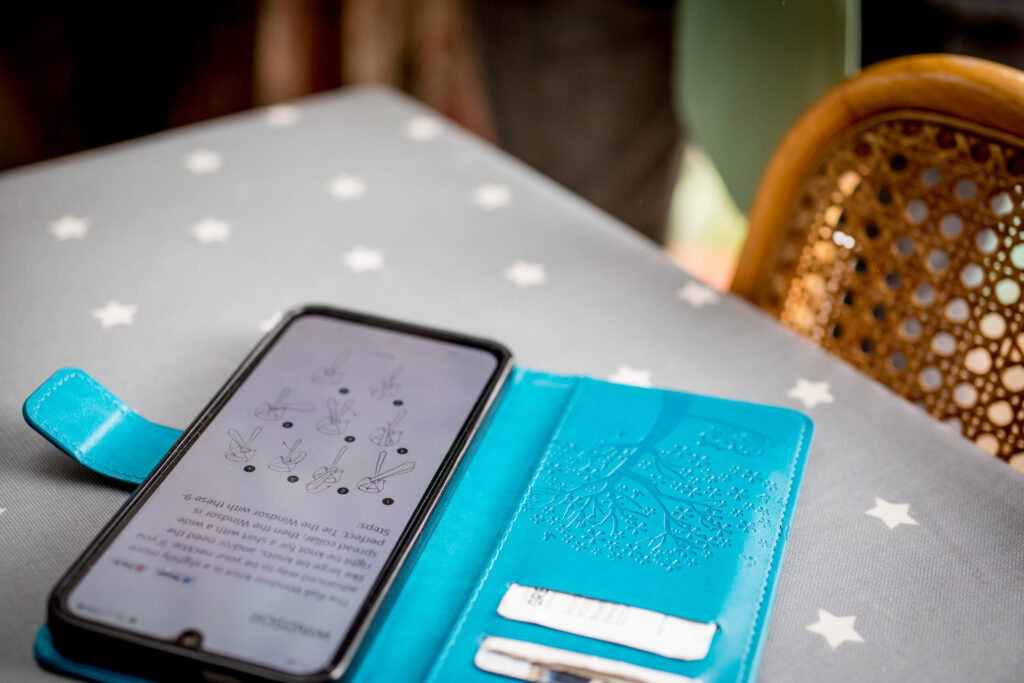 photo of a mobile phone showing instructions on how to do a windsor knot