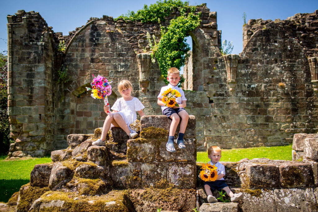 informal photo of children at croxden abbey holding wedding flowers