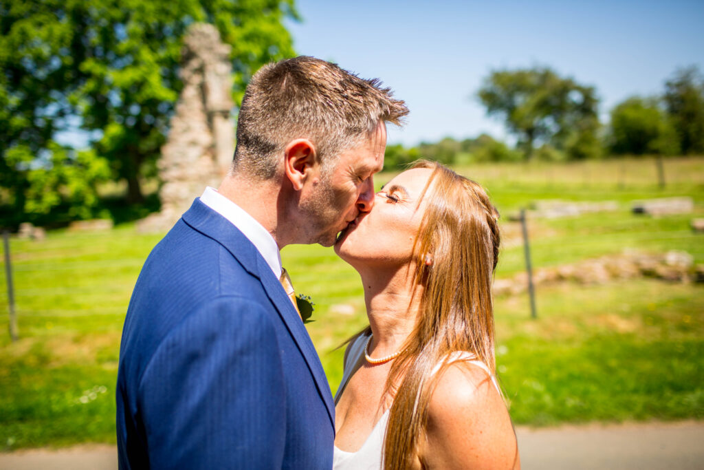 bride and groom kissing in the sun