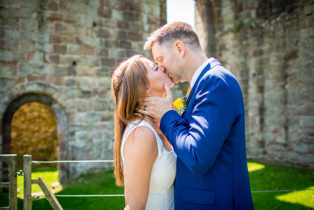 groom kissing bride holding her face