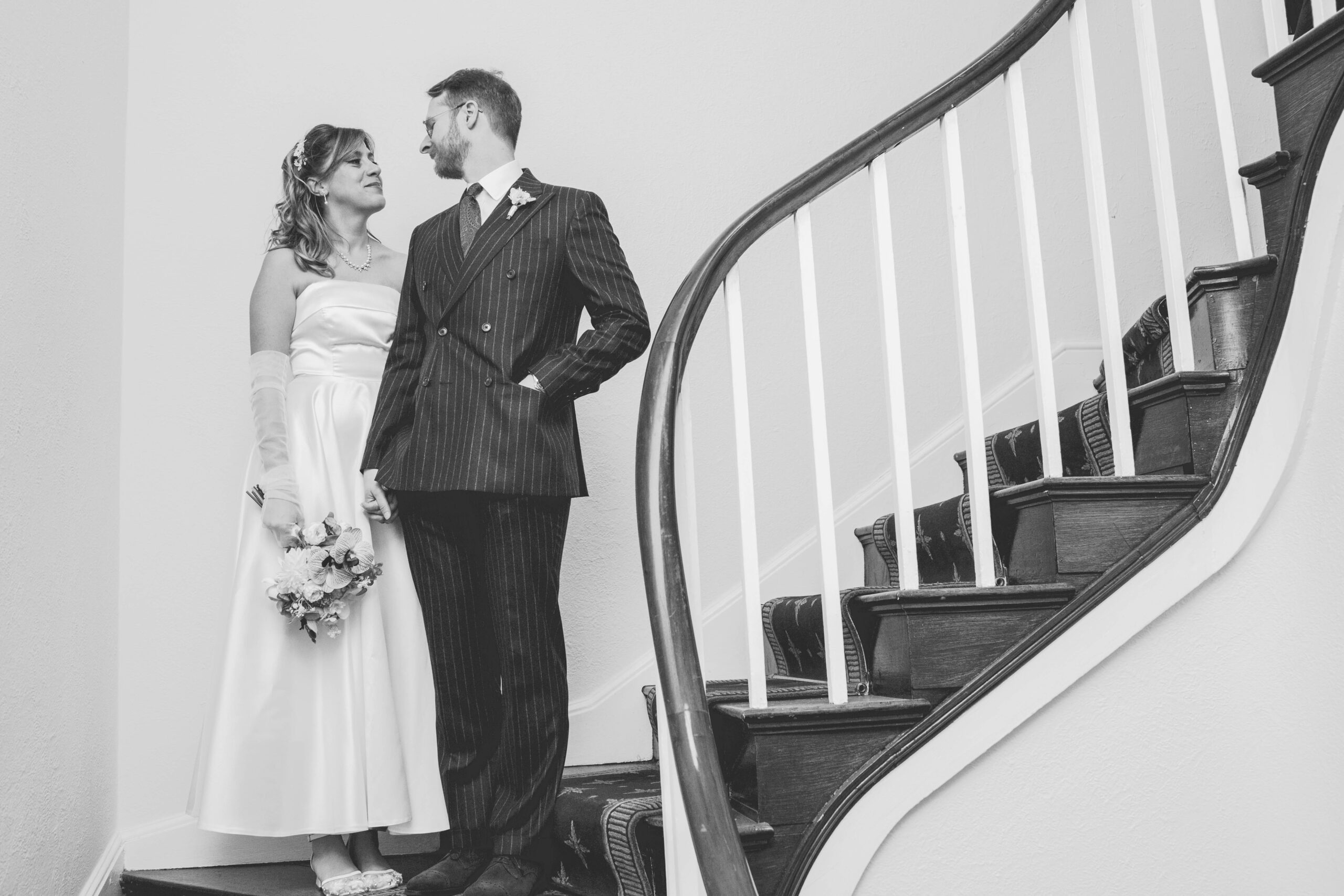Staffordshire-weddiing-photographer6 black and white photo of couple stood on stairs in stafford registry office
